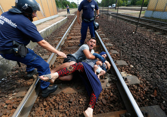 بالفيديو.. لاجئ سوري وزوجته وطفلهما يستلقون على سكة القطار في مشهد يدمي القلوب صورة رقم 2