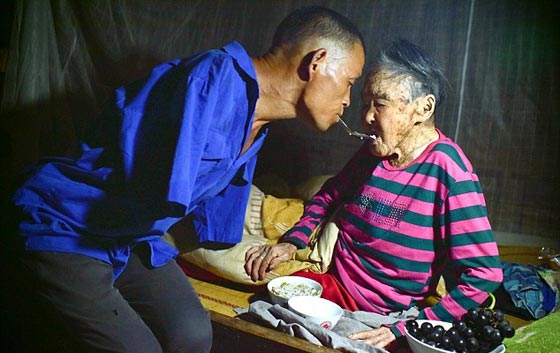 صورة ادهشت الملايين.. مبتور الذراعين يطعم والدته المريضة بفمه صورة رقم 2