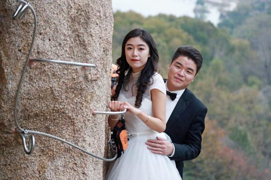 صور غريبة: زوجان صينيان يتزوجان على منحدر جبلي في أخطر حفل زفاف!  صورة رقم 1