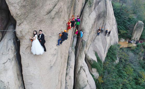 صور غريبة: زوجان صينيان يتزوجان على منحدر جبلي في أخطر حفل زفاف!  صورة رقم 2