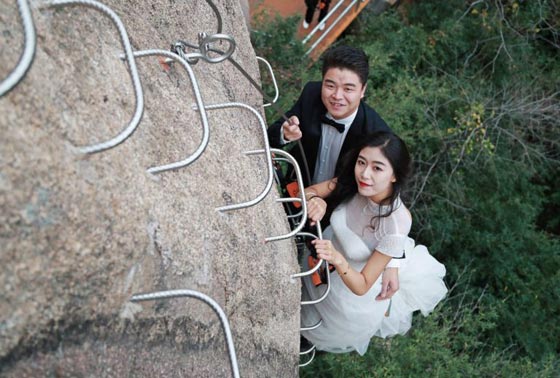 صور غريبة: زوجان صينيان يتزوجان على منحدر جبلي في أخطر حفل زفاف!  صورة رقم 3
