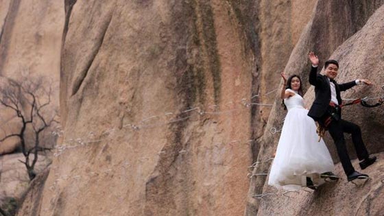 صور غريبة: زوجان صينيان يتزوجان على منحدر جبلي في أخطر حفل زفاف!  صورة رقم 4