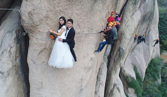 صور غريبة: زوجان صينيان يتزوجان على منحدر جبلي في أخطر حفل زفاف!  صورة رقم 6