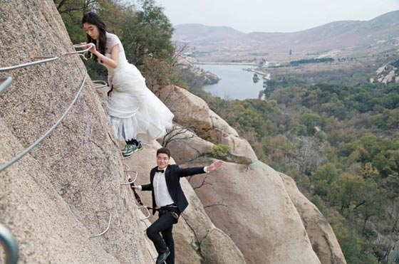 صور غريبة: زوجان صينيان يتزوجان على منحدر جبلي في أخطر حفل زفاف!  صورة رقم 7