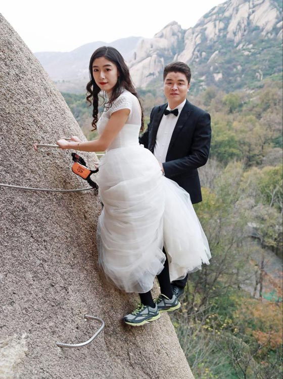 صور غريبة: زوجان صينيان يتزوجان على منحدر جبلي في أخطر حفل زفاف!  صورة رقم 8