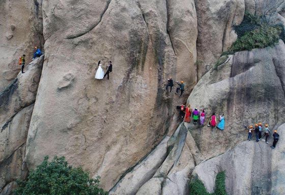 صور غريبة: زوجان صينيان يتزوجان على منحدر جبلي في أخطر حفل زفاف!  صورة رقم 9