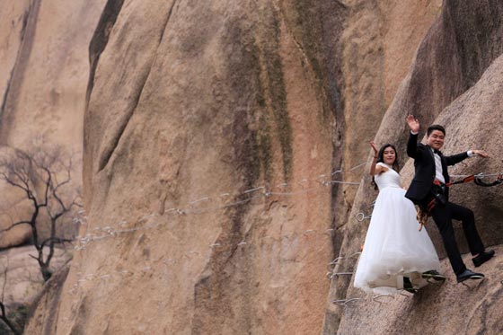 صور غريبة: زوجان صينيان يتزوجان على منحدر جبلي في أخطر حفل زفاف!  صورة رقم 10