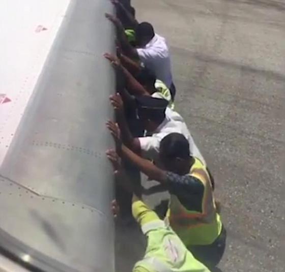 بالفيديو: رجال يدفعون طائرة.. والركاب يصورون  صورة رقم 2