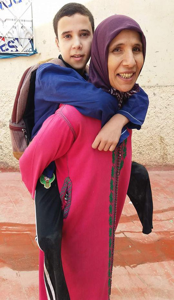 فيديو مؤثر.. أم مغربية تحمل ابنها المعاق يوميا على ظهرها إلى المدرسة! صورة رقم 1