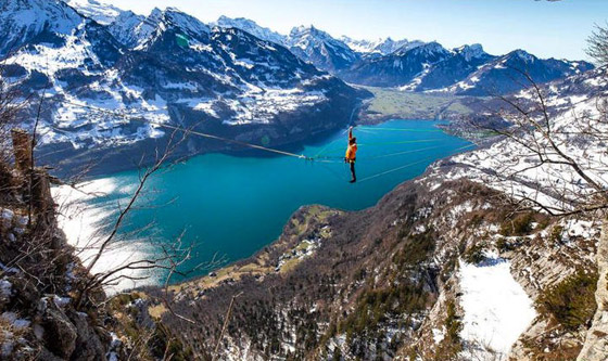 رياضي يقوم بألعاب أكروباتية مرعبة على ارتفاع شاهق فوق بحيرة سويسرية صورة رقم 1