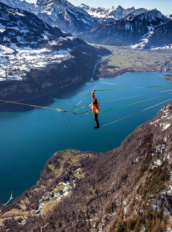 رياضي يقوم بألعاب أكروباتية مرعبة على ارتفاع شاهق فوق بحيرة سويسرية صورة رقم 4