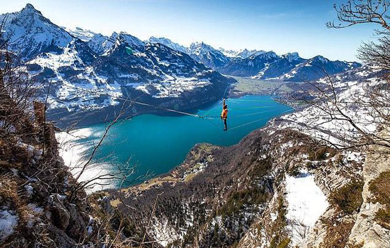 رياضي يقوم بألعاب أكروباتية مرعبة على ارتفاع شاهق فوق بحيرة سويسرية صورة رقم 5