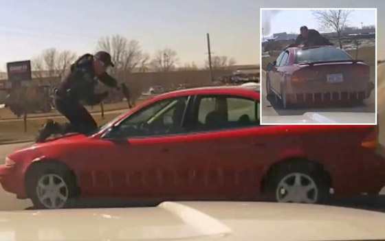  صورة رقم 2 - فيديو يحبس الأنفاس: شرطي تشبث بغطاء سيارة قادها سائقها بسرعة عالية!
