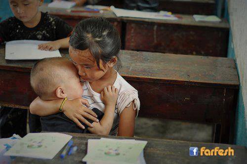 طفلة صغيرة تلميذة تعتني بأخيها الصغير في المدرسة لأن أمهما تعمل من أجل لقمة العيش